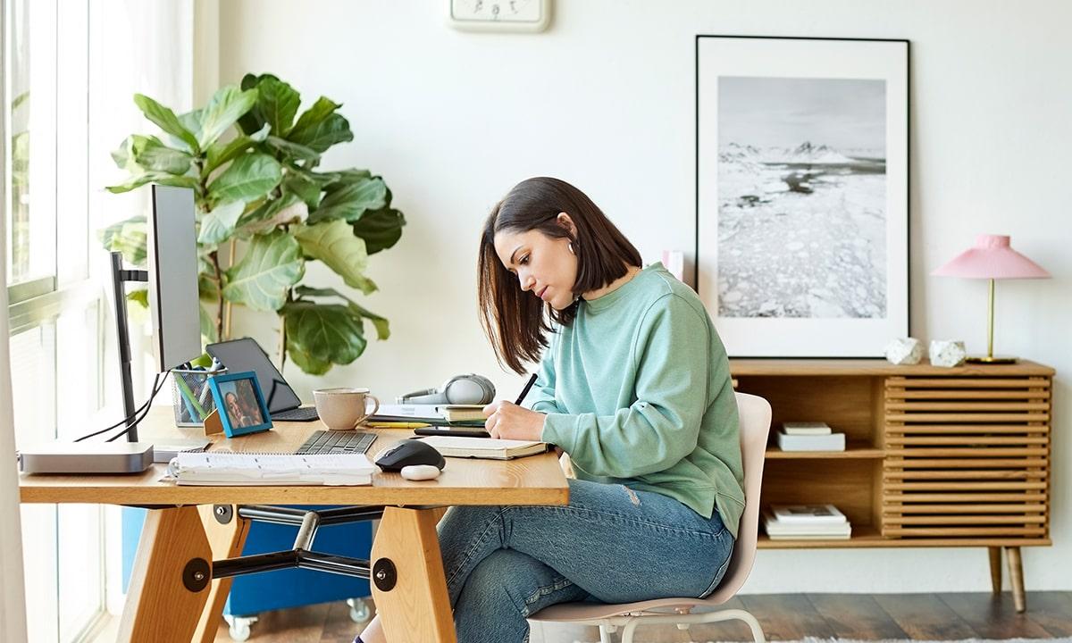 Female engineer takes notes in a notebook at home through a remote role