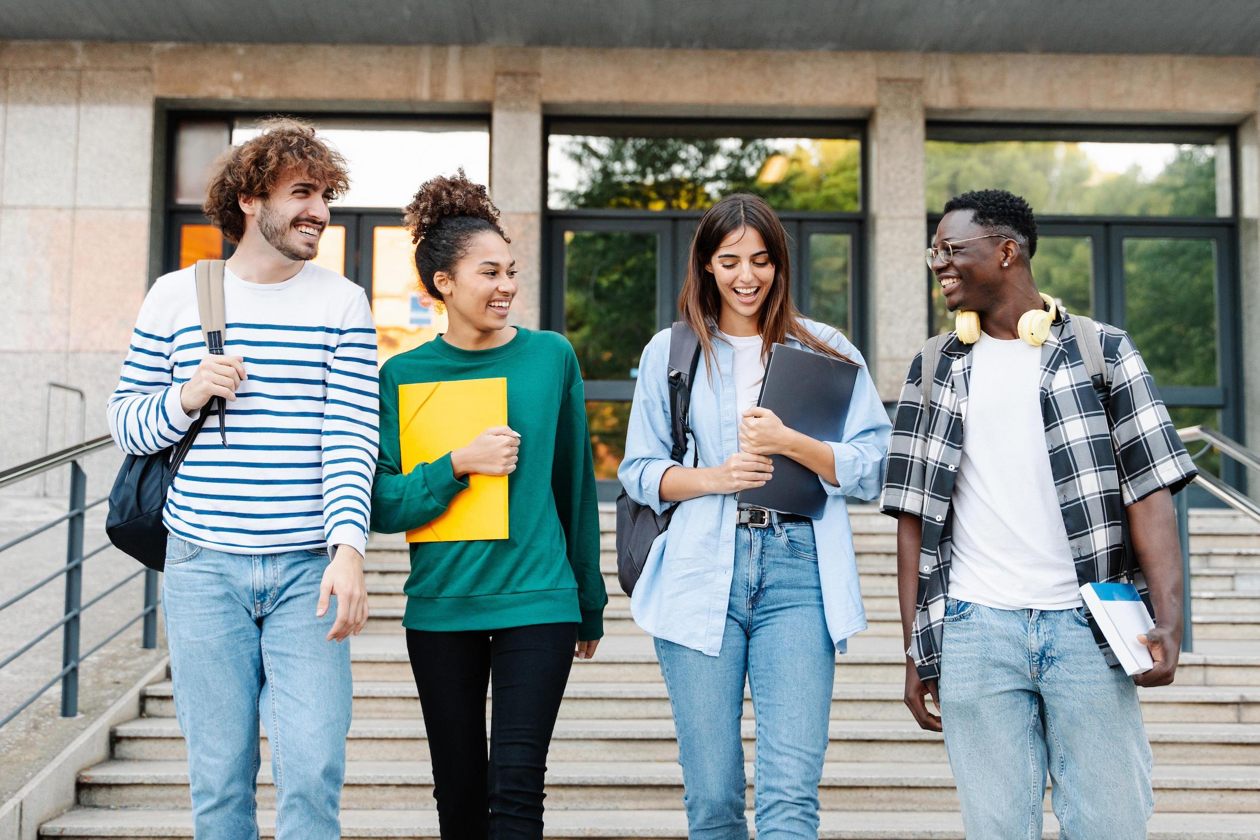 Students walking together on university campus, chatting and laughing outdoors after classes